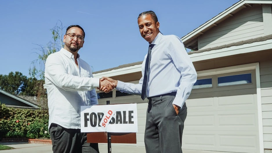Consultor sonriente dando la mano a un cliente en una oficina moderna